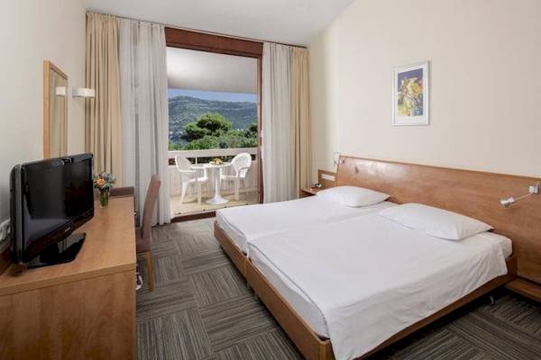 Hotelzimmer im Valamar Tirena Hotel mit Balkon und Blick auf die Berge.