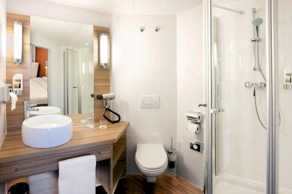 Ein modernes Badezimmer im Star Inn Hotel Wien Schönbrunn mit einer Dusche, Toilette und Waschbecken.