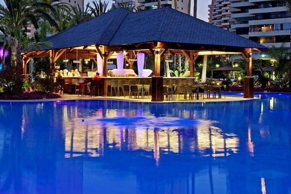 Poolbar des Sol Principe Hotels mit bunten Lichtern und Gästen.