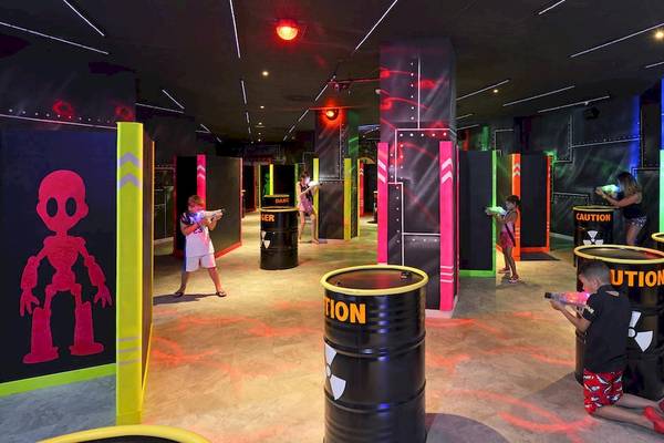 Kinder spielen Laser Tag in einem farbenfrohen Spielbereich des Sol Principe Hotels.