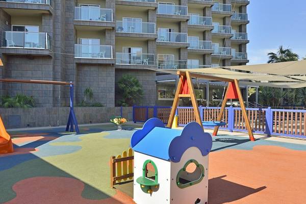 Kinderspielplatz vor dem Sol Principe Hotel mit Rutsche, Schaukel und Sandkasten.