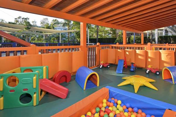 Spielplatz im Sol Principe Hotel mit bunten Spielsachen und einem überdachten Bereich.