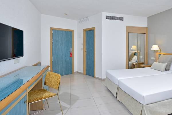 Hotelzimmer im Sol Principe mit zwei Betten, Fernseher, Schreibtisch und Türen.