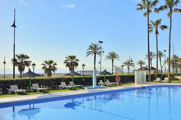Außenpool am Sol Principe Hotel mit Sonnenliegen und Palmen im Hintergrund.