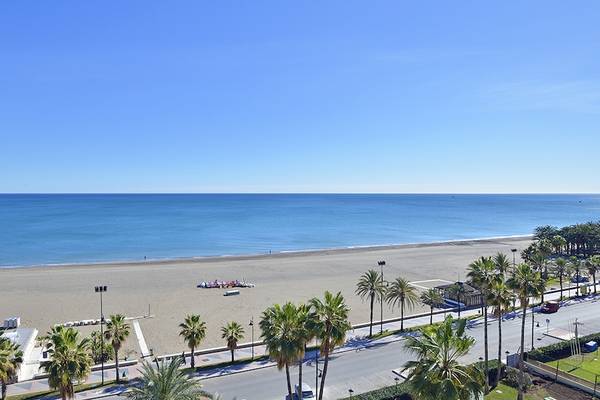 Aussicht auf den Strand von Sol Principe Hotel mit Palmen und blauem Himmel