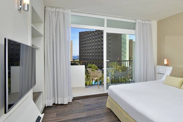 Zimmer im Sol Principe Hotel mit Balkon und Meerblick, Fernseher und bequemem Bett.