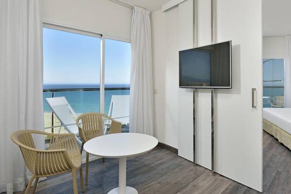 Hotelzimmer im Sol Principe mit Meerblick, inklusive Bett, Fernseher, Tisch und Stühlen.