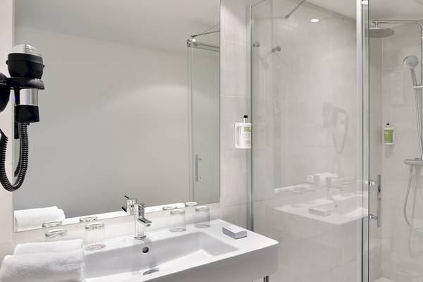 Ein modernes Badezimmer mit einer Glasdusche, einem Waschbecken und einem Spiegel im Sol Principe Hotel.