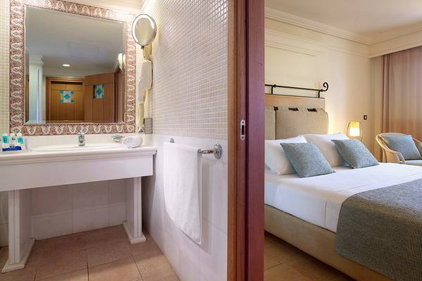 Hotelzimmer mit Badezimmer und Bett im Aldemar Knossos Royal Resort