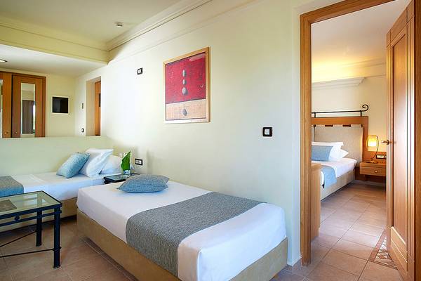 Hotelzimmer im Aldemar Knossos Royal Resort mit zwei Betten und Blick auf ein angrenzendes Zimmer.