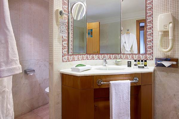 Badezimmer mit Spiegel und Handtuchhalter im Aldemar Knossos Royal Resort.