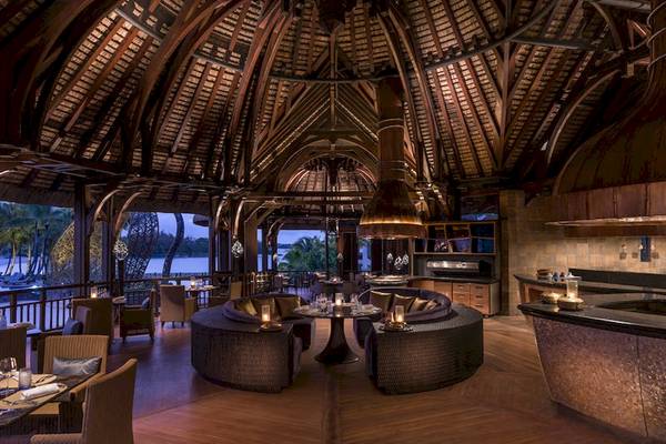 Innenbereich des Shangri-La Le Touessrok Restaurants mit Holzboden, Holzbalkendecke und Blick auf den See.