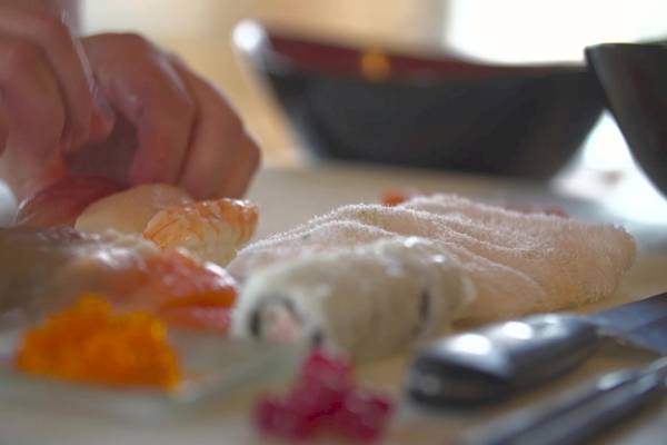 Eine Person bereitet Sushi auf einer Platte im Shangri-La Le Touessrok Hotel vor.
