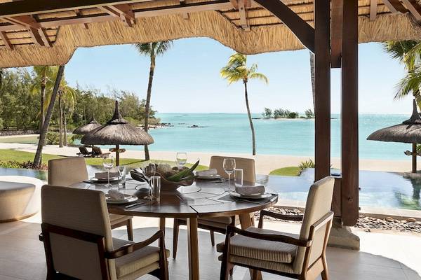 Terrasse des Shangri-La Le Touessrok Hotels mit Blick auf den Ozean und eine bewaldete Küste.
