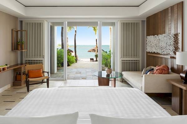 Hotelzimmer mit Meerblick im Shangri-La Le Touessrok, inklusive Bett, Fernseher und Wohnzimmerbereich.