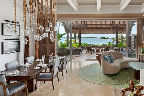 Shangri-La Le Touessrok Innenraum Wohnzimmer mit Esstisch, Sofa und Blick auf das Meer.