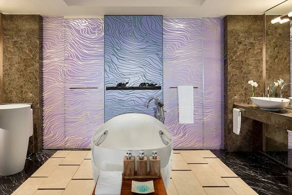 Luxus Badezimmer im Shangri-La Le Touessrok mit zwei Waschbecken, Badewanne und Spiegeln.