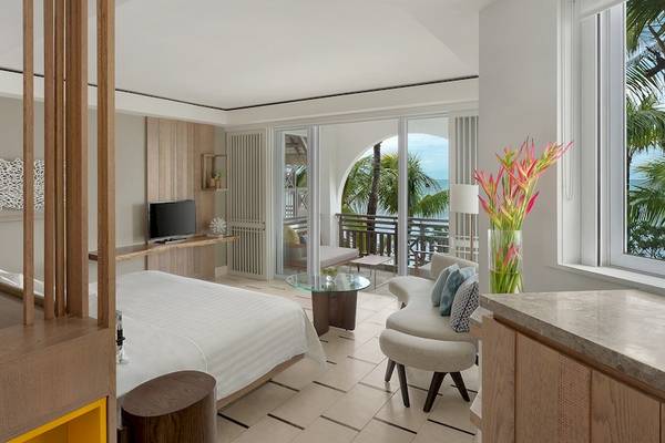 Hotelzimmer mit Balkon im Shangri-La Le Touessrok mit modernen Möbeln, Fernseher und Ausblick auf den Ozean.