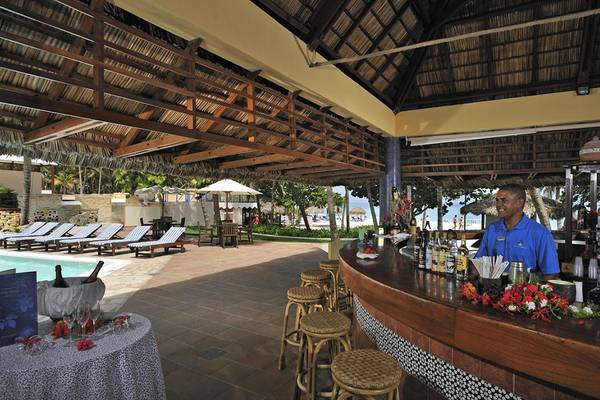 Mitarbeiter an der Poolbar des Melia Las Americas Hotels mit Blick auf einen Pool und Sonnenliegen.