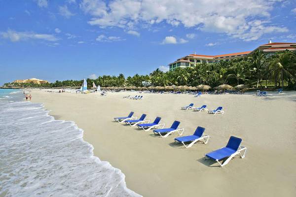 Strand am Melia Las Americas Hotel mit blauen Sonnenliegen und türkisfarbenem Wasser