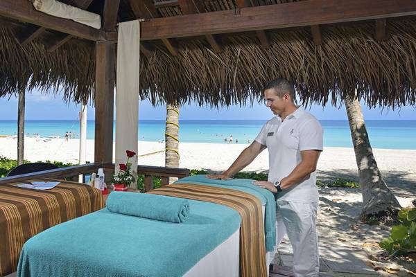 Mann, der eine Massage auf dem Strand des Melia Las Americas Hotels vorbereitet.
