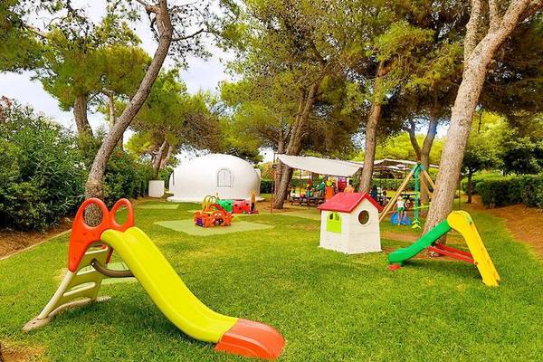 Kinderspielplatz im VOI Alimini Resort mit Spielgeräten und einer weißen Zeltstruktur.