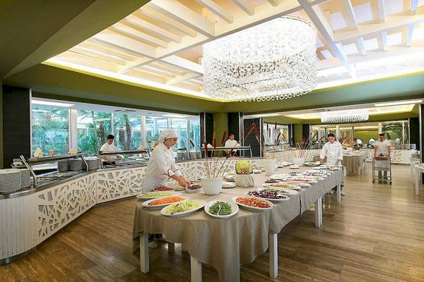 Buffetbereich im VOI Alimini Resort mit mehreren Köchen, die Speisen zubereiten.