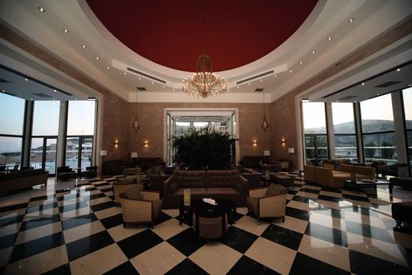 Lobby des Atlantica Belvedere Resorts mit schwarzem und weißem Schachbrettboden und einer großen Kristallkronleuchter.