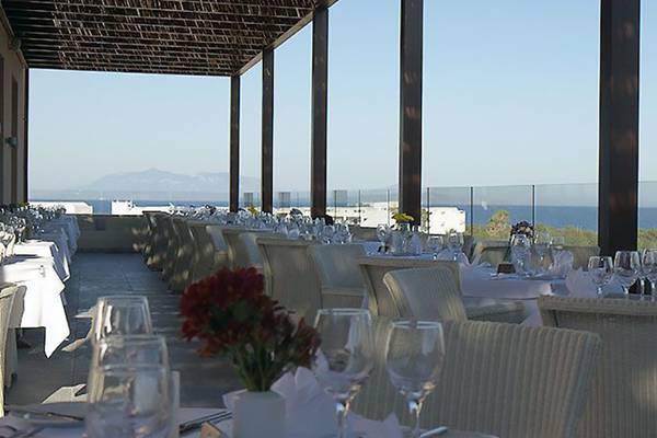 Restaurant mit Meerblick im Atlantica Belvedere Resort, gedeckte Tische und Stühle draußen.