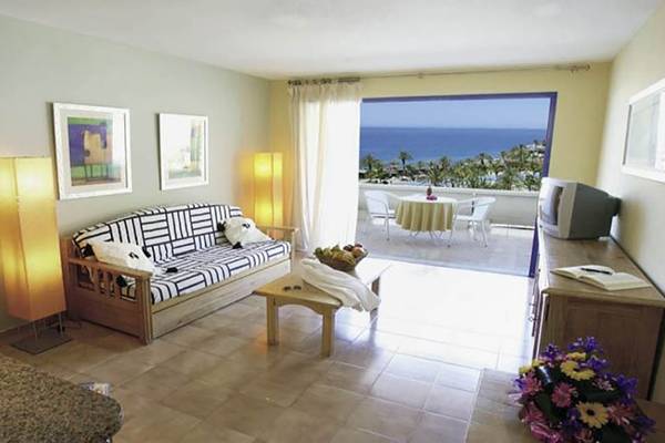 Balkonzimmer im LIVVO Lago Taurito Hotel mit Meerblick, Sofa und Tisch.