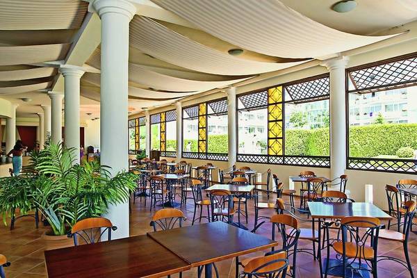 Innenansicht des Restaurants im DAS Club Hotel Sunny Beach mit runden Tischen und Stühlen.