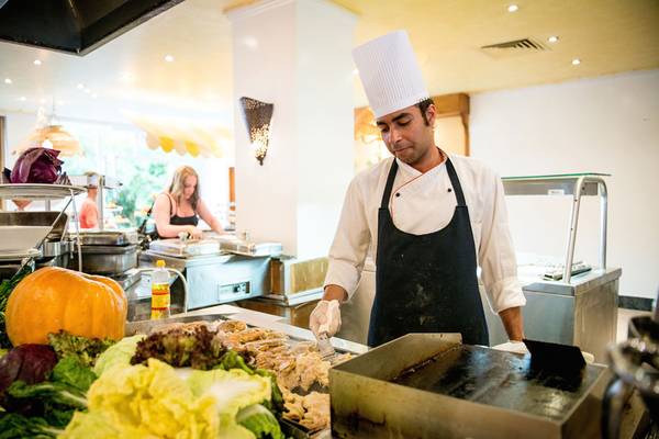 Koch in der Küche des Siva Grand Beach Hotel, der Fleisch anbrät