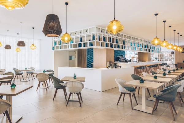 Innenbereich des Restaurants im Iberostar Selection Sabila Hotel mit Tischen, Stühlen und Lampen.