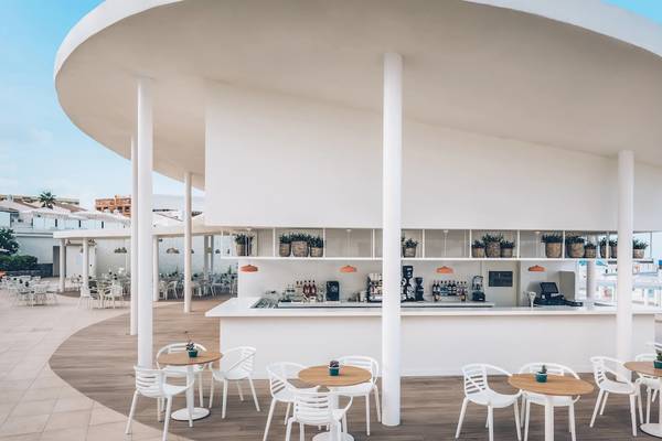Außenbereich des Iberostar Selection Sabila Hotels mit Bar, Tischen und Stühlen und Blick auf das Meer.