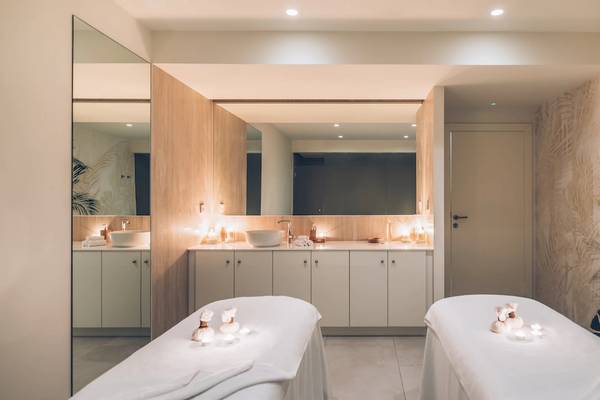 Massageraum im Iberostar Selection Sabila Hotel mit zwei Massagetischen, einem Spiegel und exotischen Wandmustern.