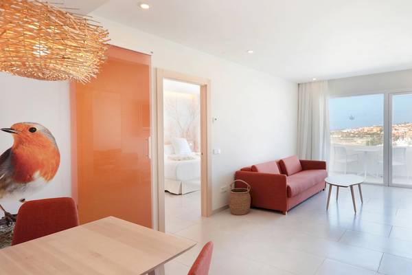 Innenansicht eines Zimmers im Iberostar Selection Sabila Hotel mit Wohnzimmer, Esstisch, Schlafbereich und Balkon.