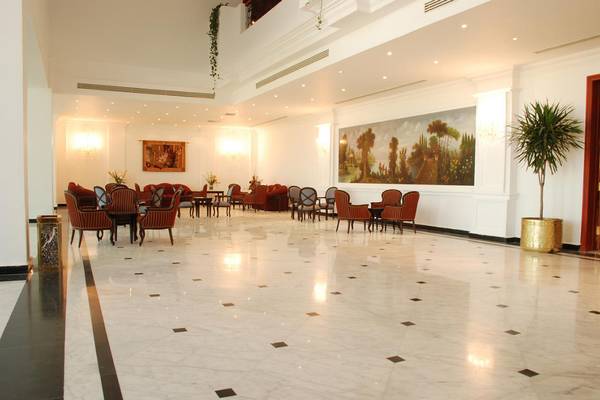 Lobby des Pyramisa Beach Resort Sahl Hasheesh mit Marmorboden, Möbeln und einer großen Wandmalerei.