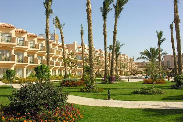 Außenansicht des Pyramisa Beach Resort Sahl Hasheesh mit mehreren Gebäuden und Palmen.