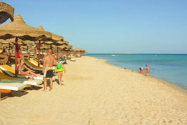 Strandszene mit Sonnenliegen, Sonnenschirmen und Badegästen am Pyramisa Beach Resort Sahl Hasheesh
