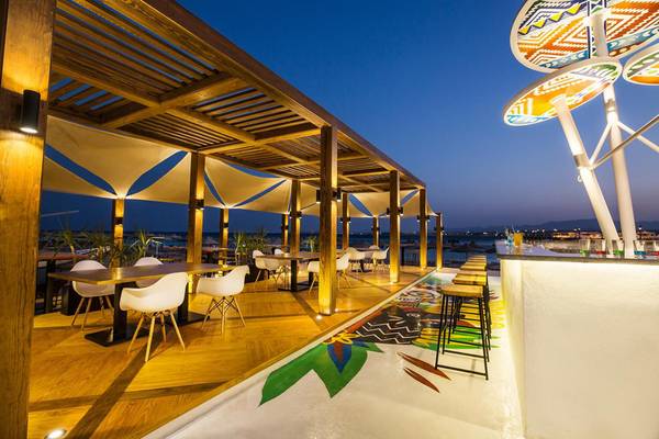 Terrasse des Pyramisa Beach Resort Sahl Hasheesh bei Nacht mit beleuchteten Tischen und Stühlen.