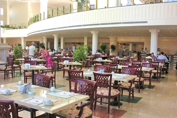Innenansicht des Restaurants im Pyramisa Beach Resort Sahl Hasheesh mit Gästen an Tischen.