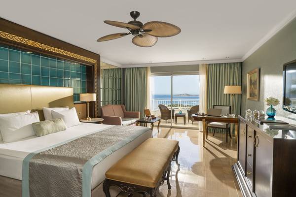 Hotelzimmer mit Meerblick im Rixos Premium Bodrum mit einem großen Bett, Balkon und Blick auf das Meer.