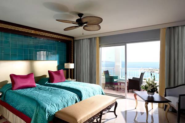 Doppelzimmer mit Meerblick im Rixos Premium Bodrum mit zwei Betten, Balkon und Blick auf das Meer.