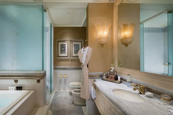 Das Badezimmer des Emirates Palace Mandarin Oriental mit Badewanne, Dusche, Toilette und Waschbecken.