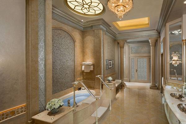 Luxuriöses Badezimmer im Emirates Palace Mandarin Oriental mit Badewanne, zwei Waschbecken und Kristallkronleuchter.
