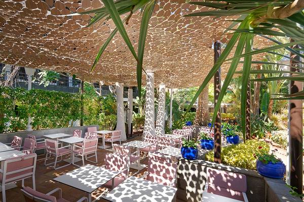 Außenterrasse des Parque Tropical Hotels mit Tischen und Stühlen unter einem Pergola-Dach.