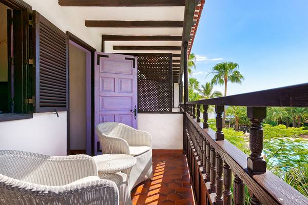 Terrasse des Parque Tropical Hotels mit Blick auf einen Swimmingpool und Palmen