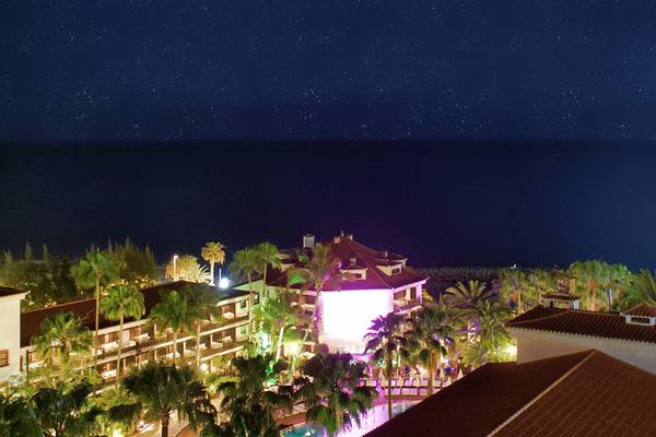 Nachtsicht auf das Hotel Parque Tropical am Strand mit Mond und Sternenhimmel