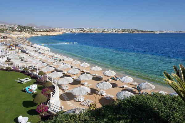 Luftaufnahme des Sonnenaufgang Arabian Beach Resorts mit vielen Sonnenschirmen und Liegen am Strand