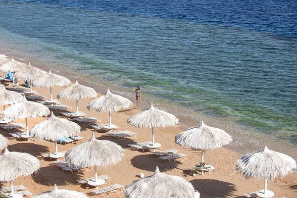 Luftaufnahme des Sunrise Arabian Beach Resorts Strand mit vielen Sonnenschirmen und Liegestühlen